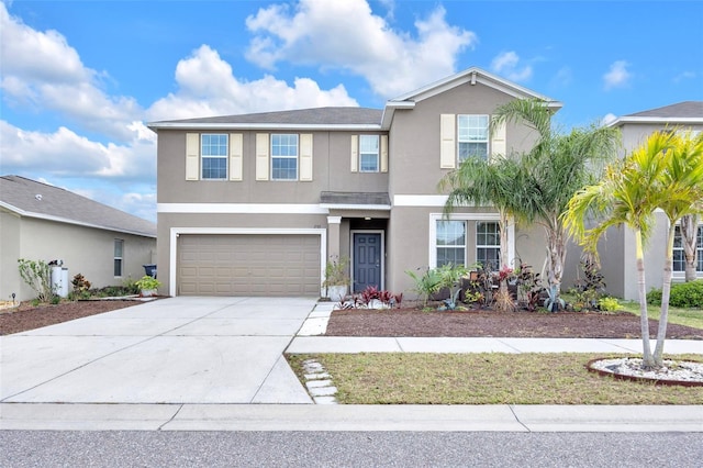 traditional-style house with driveway, an attached garage, and stucco siding