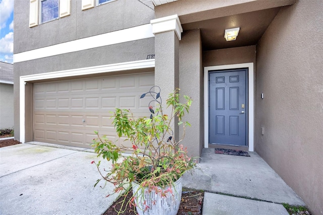 entrance to property with driveway and stucco siding