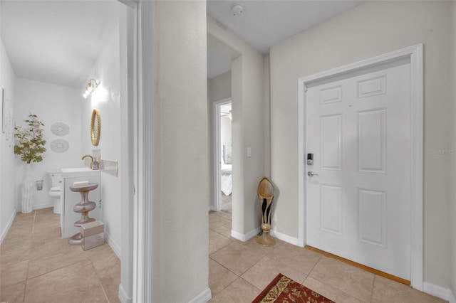 foyer with baseboards and light tile patterned floors