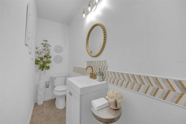 bathroom featuring toilet, tile patterned flooring, and a sink