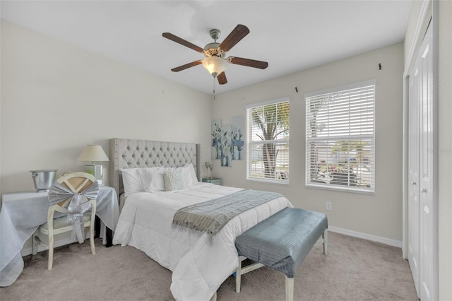 bedroom with ceiling fan, a closet, carpet flooring, and baseboards