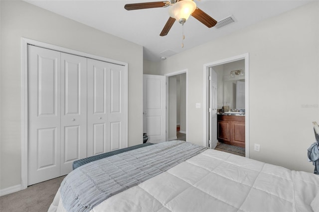 bedroom featuring a closet, visible vents, ensuite bathroom, carpet flooring, and ceiling fan