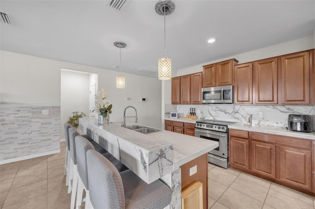 kitchen featuring light tile patterned floors, stainless steel appliances, light countertops, visible vents, and a sink