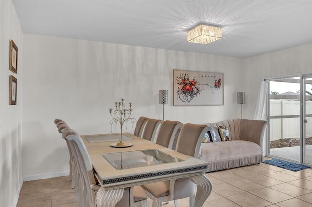 dining area with baseboards and light tile patterned flooring