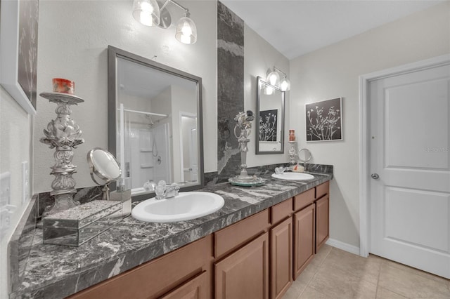 bathroom featuring double vanity, a shower stall, a sink, and tile patterned floors