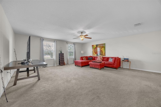 living room with light colored carpet, visible vents, a ceiling fan, a textured ceiling, and baseboards