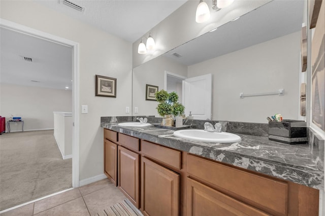 bathroom with a sink, visible vents, and tile patterned floors