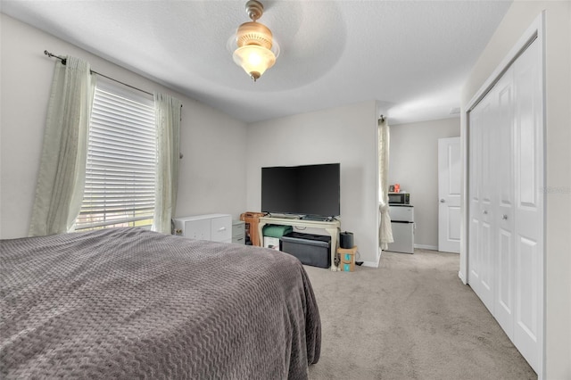 bedroom featuring a textured ceiling, a closet, baseboards, and carpet flooring