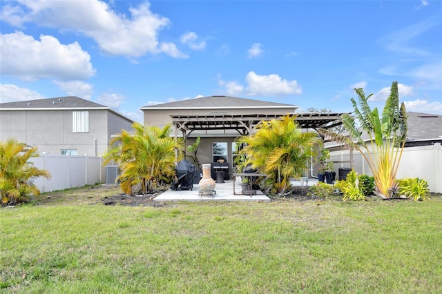 back of house featuring a yard, central AC unit, a patio, and a fenced backyard