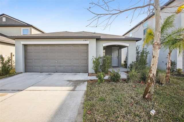 view of front of house featuring an attached garage, driveway, and stucco siding