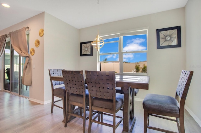 dining space featuring a wealth of natural light, light wood-type flooring, and baseboards