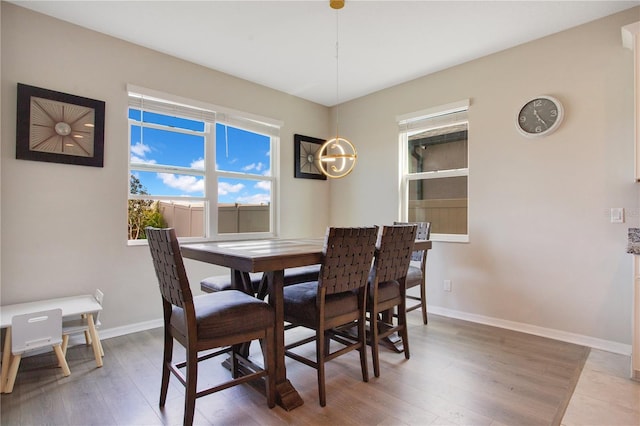 dining space featuring baseboards and light wood-style floors