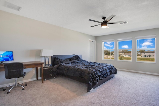 bedroom featuring visible vents, a textured ceiling, carpet floors, baseboards, and ceiling fan