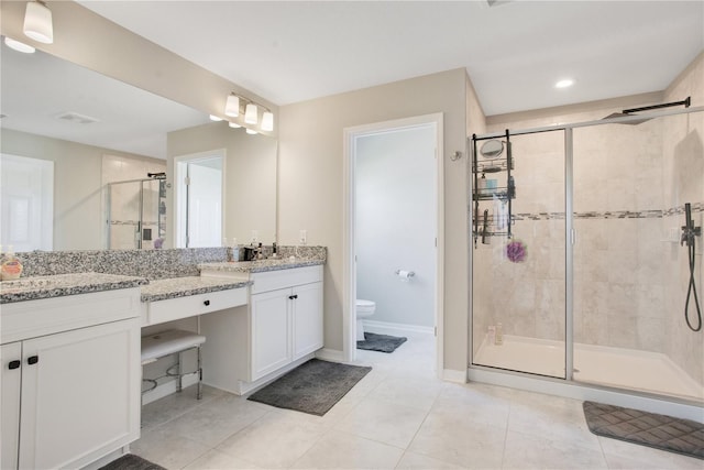 bathroom featuring vanity, baseboards, a shower stall, tile patterned floors, and toilet