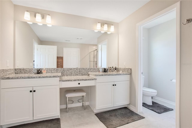 bathroom with baseboards, vanity, toilet, and a shower stall