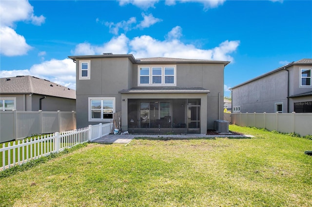 back of property featuring stucco siding, a lawn, a fenced backyard, and a sunroom