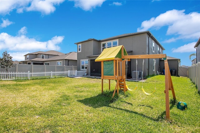 rear view of property featuring a residential view, stucco siding, a lawn, and a fenced backyard