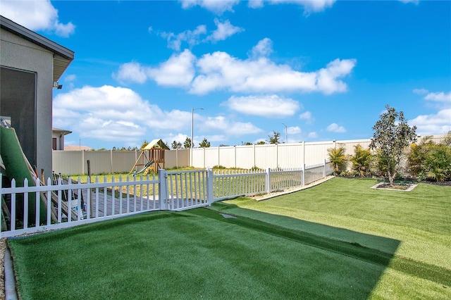 view of yard with a playground and a fenced backyard