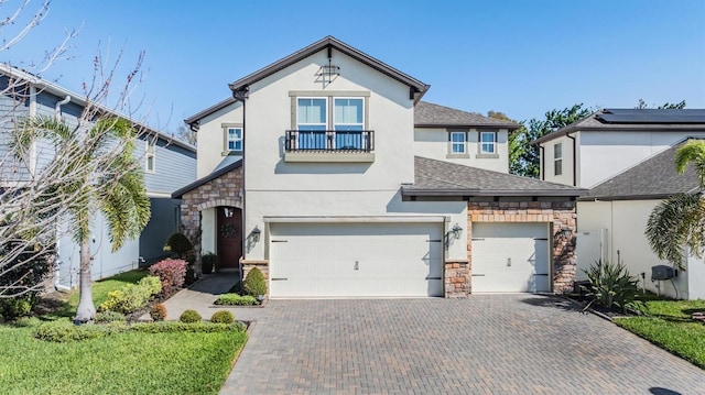 view of front of home with a shingled roof, decorative driveway, stone siding, and stucco siding