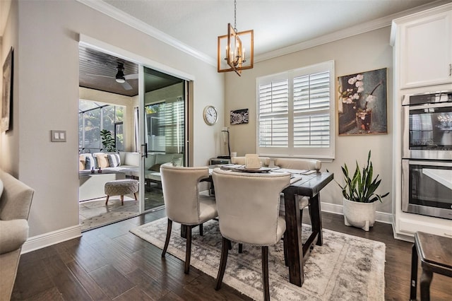 dining area with ceiling fan with notable chandelier, crown molding, baseboards, and dark wood-style flooring