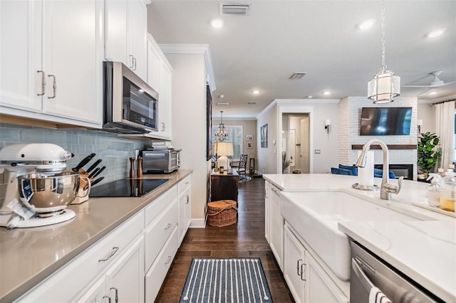 kitchen featuring a sink, stainless steel appliances, visible vents, and dark wood-style floors