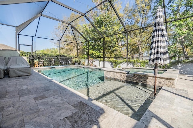 view of swimming pool featuring glass enclosure, a pool with connected hot tub, and a patio area