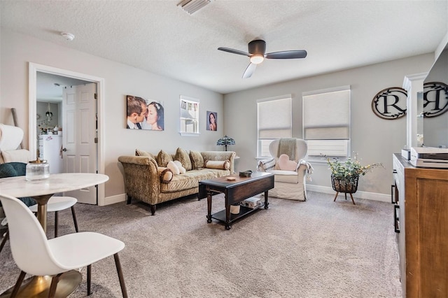 living area with light carpet, visible vents, baseboards, and a ceiling fan