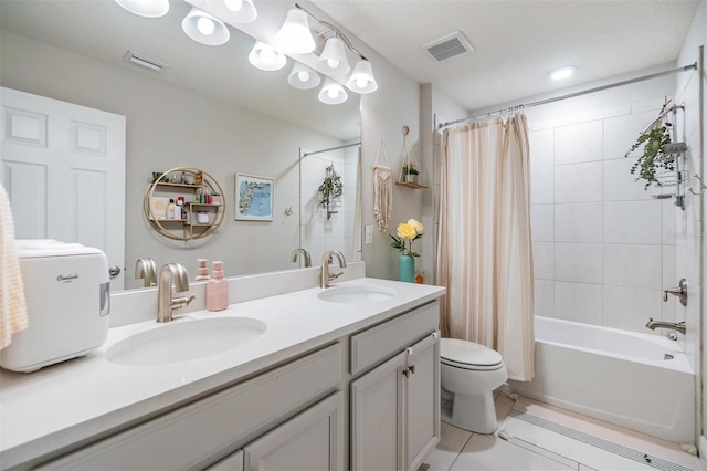 bathroom featuring toilet, visible vents, shower / tub combo with curtain, and a sink