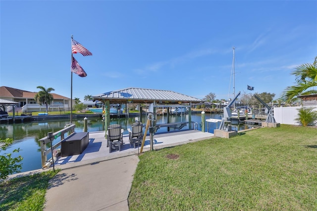 dock area featuring a water view, boat lift, and a yard