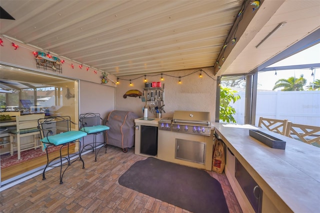 view of patio / terrace featuring glass enclosure, area for grilling, and fence