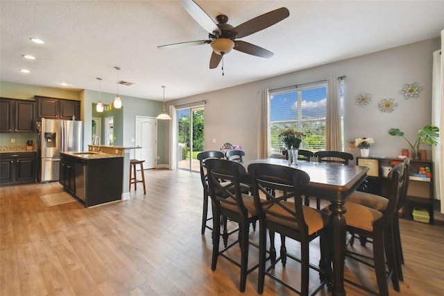 dining space with a textured ceiling, ceiling fan, recessed lighting, visible vents, and light wood finished floors