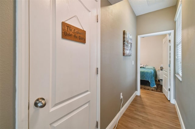 hallway with light wood-style floors and baseboards