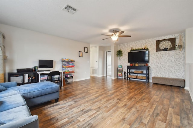 living room with baseboards, visible vents, and wood finished floors