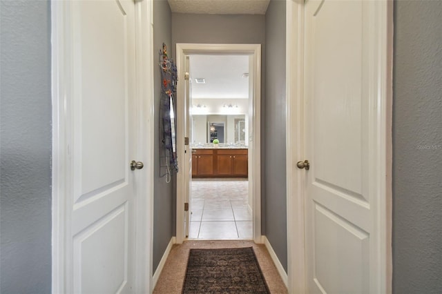 hall with visible vents and light colored carpet