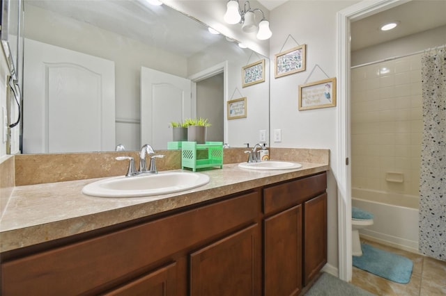 bathroom featuring double vanity, tile patterned flooring, toilet, and a sink