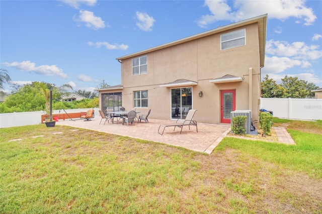 back of house with a fenced backyard, a patio, a lawn, and stucco siding