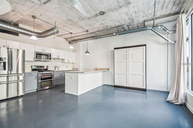 kitchen with stainless steel appliances, a peninsula, white cabinets, hanging light fixtures, and light countertops