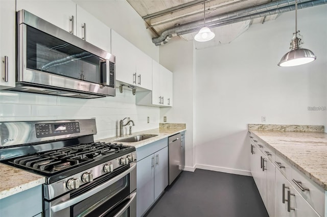 kitchen with stainless steel appliances, a sink, baseboards, backsplash, and light stone countertops