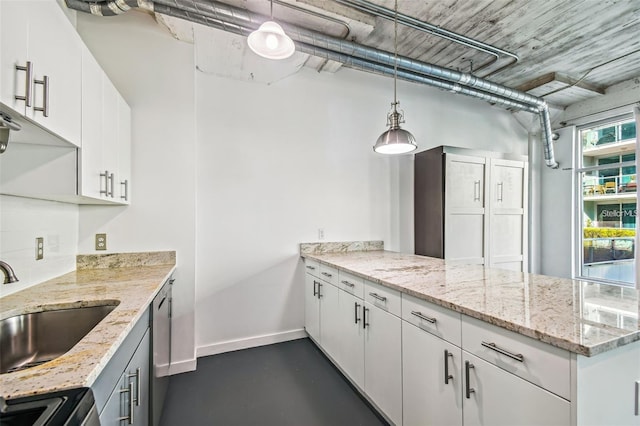 kitchen featuring light stone counters, stainless steel dishwasher, white cabinets, a sink, and a peninsula