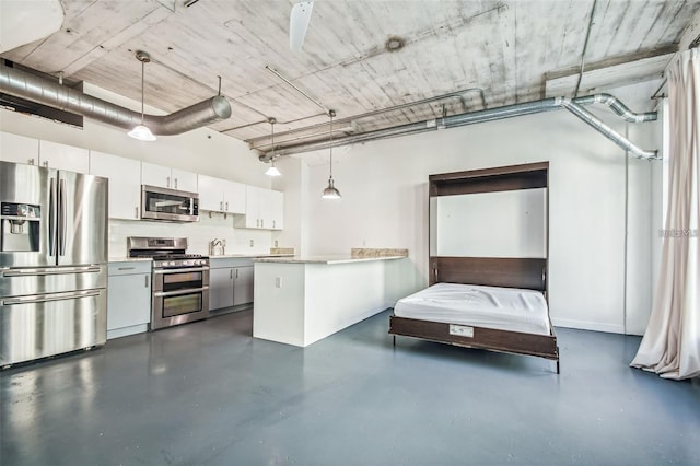 kitchen featuring appliances with stainless steel finishes, pendant lighting, white cabinets, and a peninsula