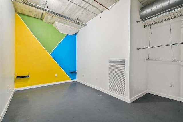 additional living space featuring finished concrete floors, visible vents, and baseboards