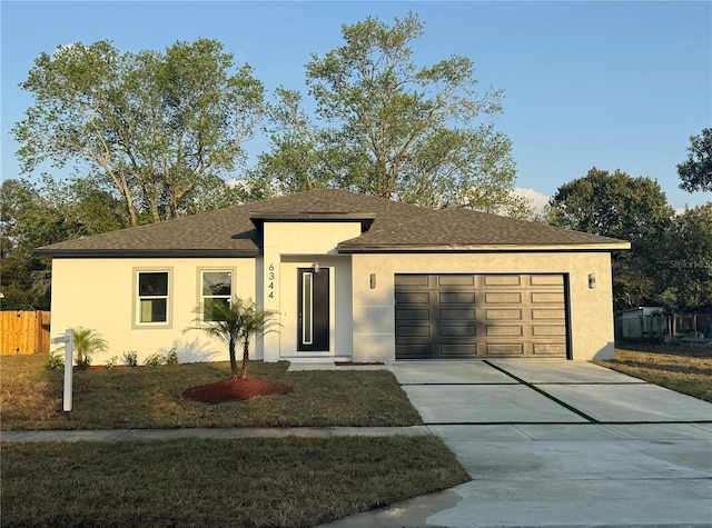 ranch-style house with fence, driveway, an attached garage, a shingled roof, and stucco siding