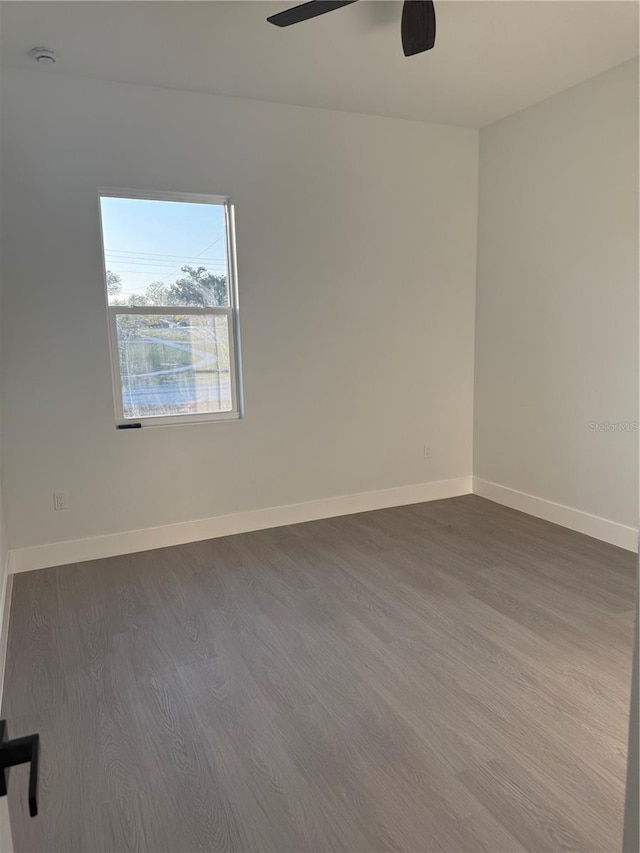 unfurnished room featuring wood finished floors, baseboards, and ceiling fan