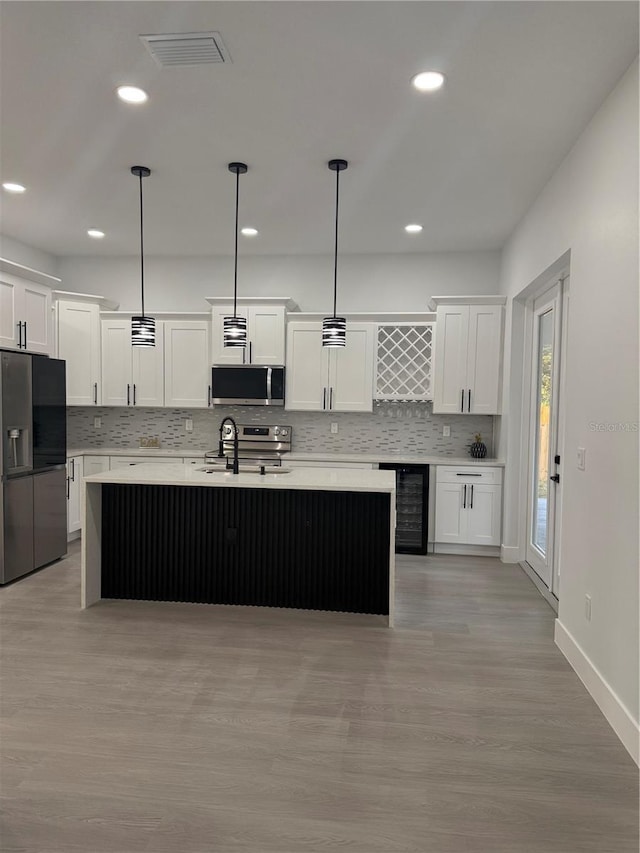 kitchen featuring light countertops, wine cooler, visible vents, and stainless steel appliances