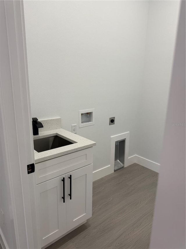 washroom with hookup for a washing machine, dark wood-style floors, baseboards, electric dryer hookup, and a sink