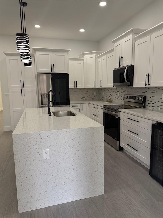 kitchen with a sink, wine cooler, backsplash, and stainless steel appliances