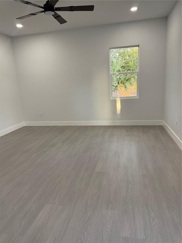 empty room featuring recessed lighting, baseboards, wood finished floors, and a ceiling fan