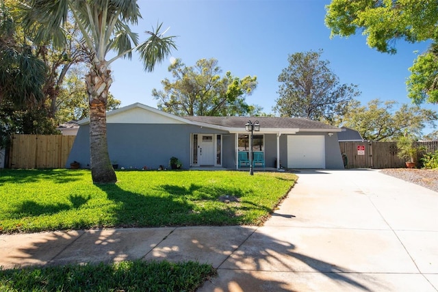 single story home with a garage, concrete driveway, stucco siding, fence, and a front yard