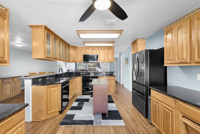 kitchen featuring light wood finished floors, glass insert cabinets, stainless steel microwave, black / electric stove, and refrigerator with ice dispenser