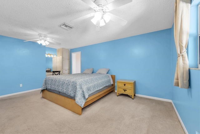 bedroom featuring visible vents, carpet flooring, ceiling fan, a textured ceiling, and baseboards